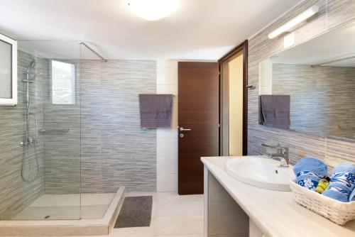 a bathroom with a sink and a glass shower at Paxos Apartments in Gaios