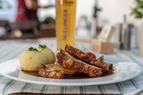 a plate of food with meat and potatoes on a table at Hotel Gasthof Krone in Zusmarshausen