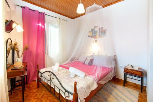 a bedroom with a bed with pink curtains at Paxos Apartments in Gaios