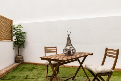 a wooden table with two chairs and a bird cage on it at Belem Design Apartments by Homing in Lisbon