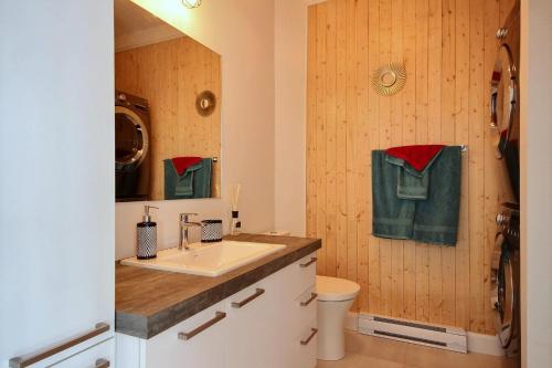 a bathroom with a sink and a toilet and green towels at Le Kaméléon 318 : interieur parking, rooftop terrace, gym in Quebec City
