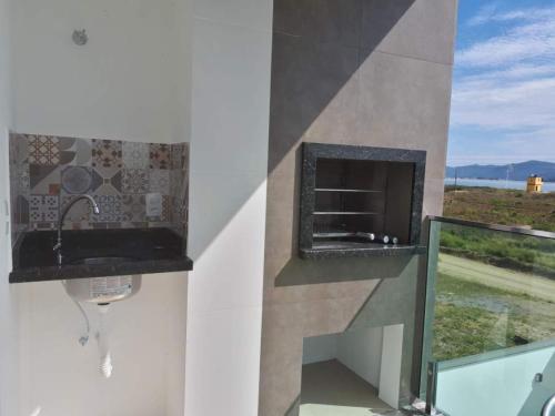 a bathroom with a fireplace and a window with a view at Beira Mar Village in Pinheira
