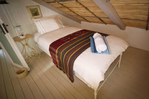 a bedroom with a large bed with a striped blanket at The Luxury Loft in Montagu
