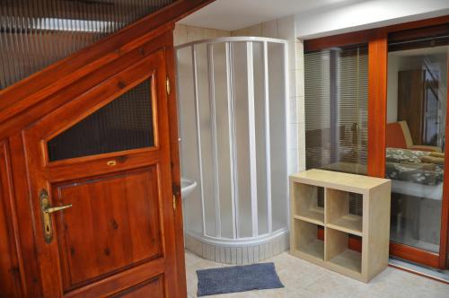 ズノイモにあるPenzion Kimexのバスルーム(バスタブ付)、木製のドアが備わります。