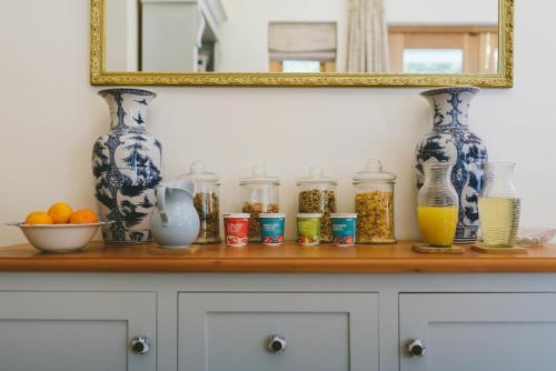 a wooden shelf with vases and jars on it at The Victorian Goose in Cape Town