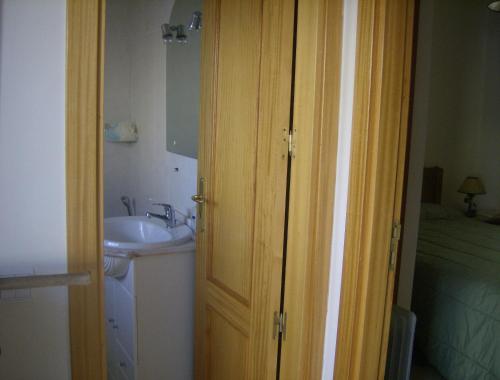 łazienka z umywalką, lustrem i drzwiami w obiekcie Apartamento Maria w Alvor