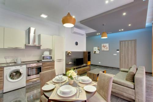 una cucina e un soggiorno con tavolo e sedie di Chalet Apartments a Sliema