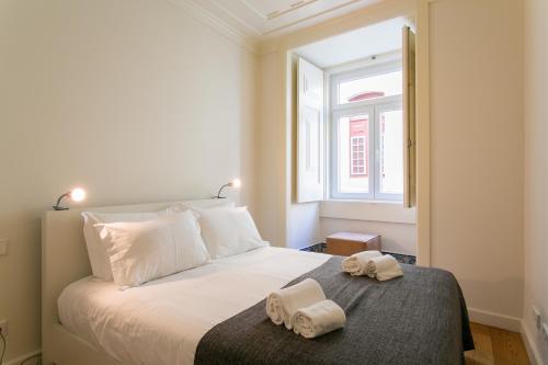 um quarto com uma cama com duas toalhas em ALTIDO Elegant 2BR Apt with workspace nearby Baixa-Chiado subway em Lisboa