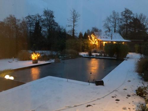 a swimming pool covered in snow at night at De Aagt Tuyn in Schoorl