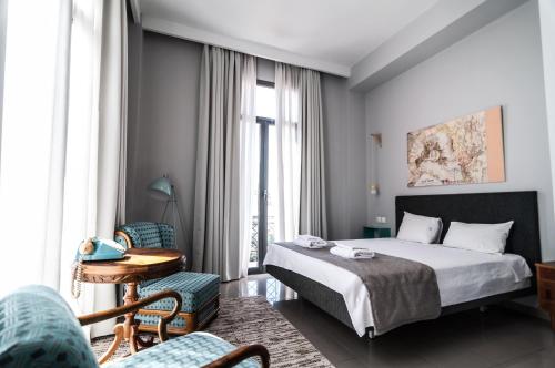 a hotel room with a bed and a table and chairs at The Caravan in Thessaloniki