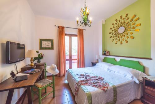 a bedroom with a bed and a desk and a television at Hotel Villa Sirina in Taormina