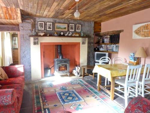 a living room with a table and a fireplace at Clooncorraun Cottage in Ballinrobe