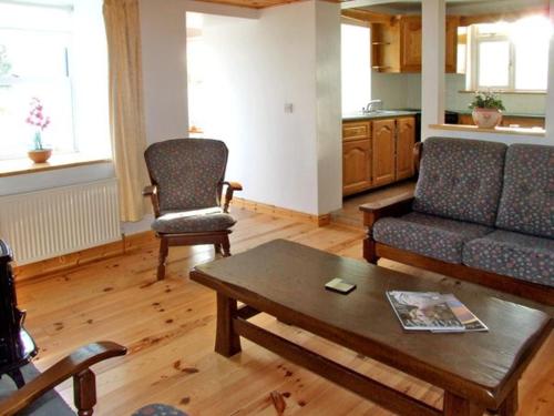 a living room with a couch and a coffee table at 1 Clancy Cottages in Kilkieran