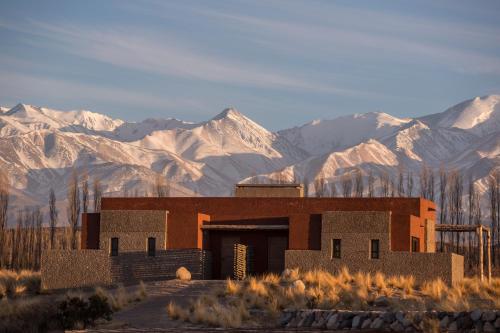 a building in the middle of a desert with mountains at Lodge Atamisque in San José