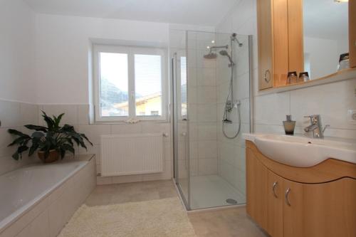 a bathroom with a shower and a sink and a tub at Ferienwohnung Frenner in Sankt Martin bei Lofer