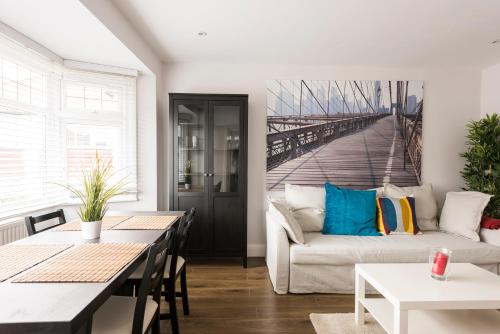 a living room with a couch and a painting of a bridge at High End Apartments in Hendon