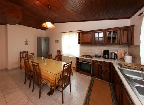 a kitchen with a table and a dining room at The Villa of the Winds in Néa Kíos