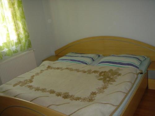 uma cama com uma cabeceira em madeira num quarto em Janó Apartman em Siófok