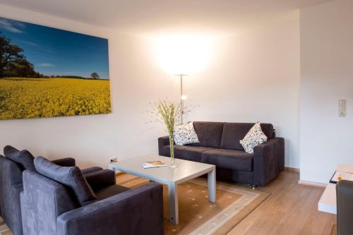 a living room with two couches and a table at Ringhotel Hohe Wacht in Hohwacht