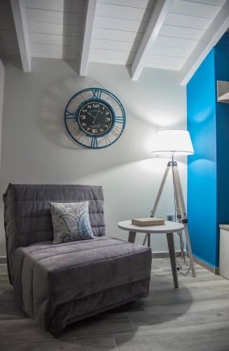 a living room with a couch and a clock on the wall at Leonidas House in Parga