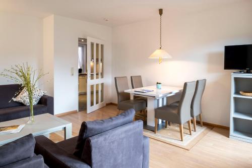 a living room and dining room with a table and chairs at Ringhotel Hohe Wacht in Hohwacht