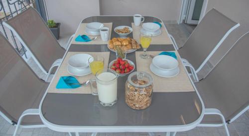 a table with breakfast foods and drinks on it at Leonidas House in Parga