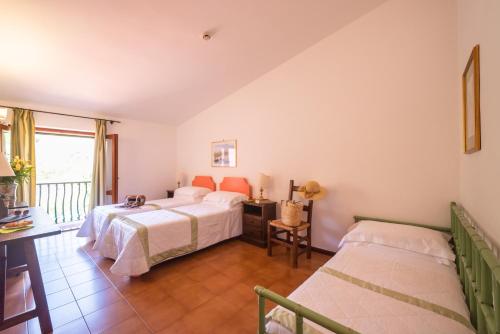 a bedroom with two beds and a balcony at Hotel Villa Sirina in Taormina