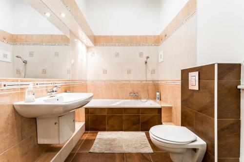 a bathroom with a sink and a toilet and a tub at BERTA - 4 Bedrooms, 3 Baths in Budapest