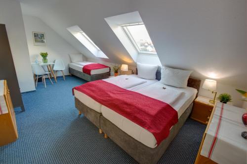 a hotel room with a bed and a table and chairs at Hotel Leo Mühlhausen in Mühlhausen