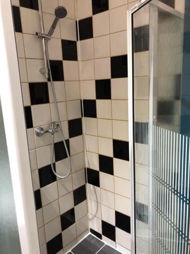 a shower with a black and white tiled at Hotel Abberdeen in Brussels