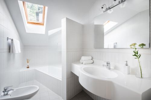 a white bathroom with two sinks and a mirror at Apartments Mühlegg in Campo Tures