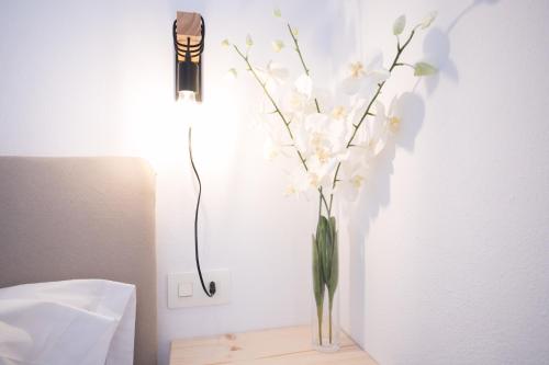 a vase filled with white flowers on a table at Villa Margarita in Es Mercadal
