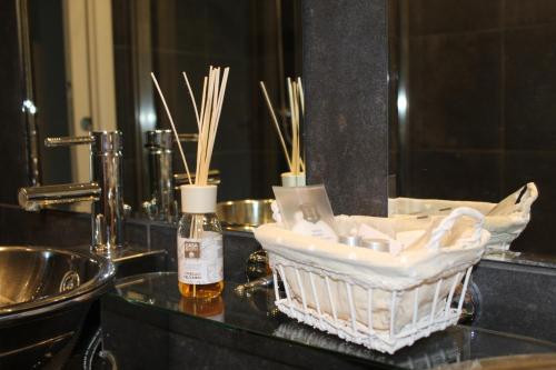a bathroom counter with a basket of soap and a mirror at B&b My Bergamo in Bergamo