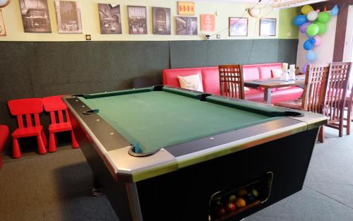 a pool table in a play room with red chairs at Willa Pod Aniołem - Pokoje Gościnne & Apartamenty z widokiem na góry in Szczyrk