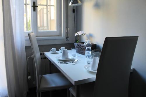 uma mesa de jantar com cadeiras e uma toalha de mesa branca em B&b My Bergamo em Bérgamo