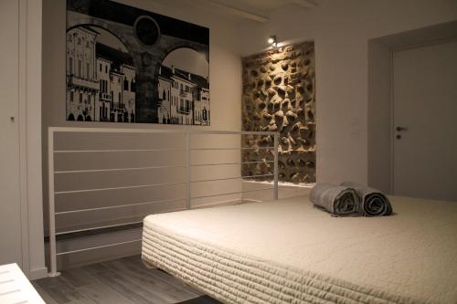 維洛納的住宿－La Barcaccia，卧室配有一张床,墙上挂有绘画作品