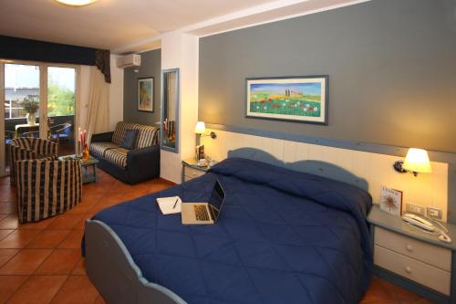 a bedroom with a blue bed with a laptop on it at Albergo Del Pino in Cercola