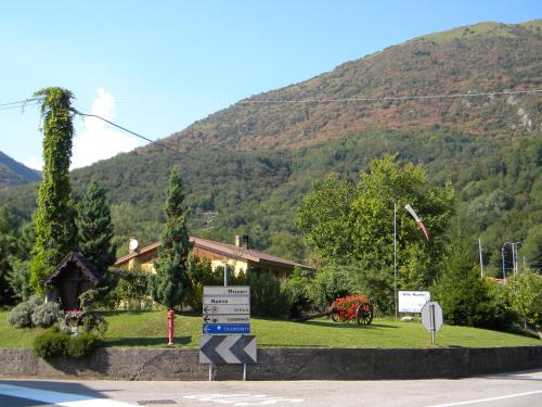 a house with a sign in front of a mountain at Agriturismo Alle Ruote in Meduno