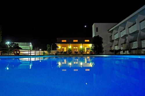 a large blue swimming pool in front of a building at Hotel Pradillo Conil in Conil de la Frontera