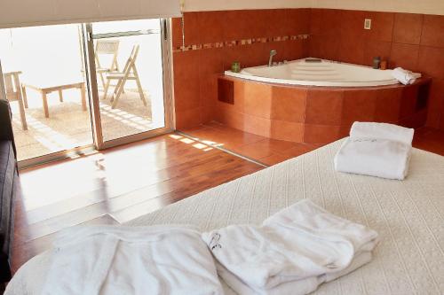 a bedroom with a bed and a bath tub at Hotel Juana de Ibarbourou in Melo