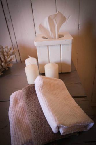a pile of towels and candles on a table at The Luxury Loft in Montagu