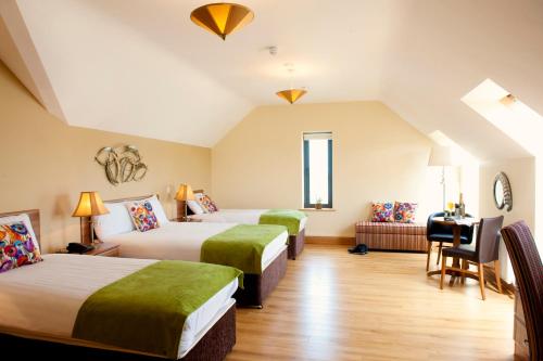 a hotel room with two beds and a desk at Kinvara Guesthouse in Kinvara