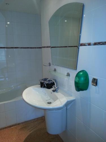 a bathroom with a sink and a mirror and a tub at Café Brasserie Het Heerenhuis in Het Kalf
