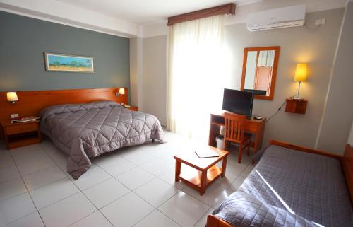 a bedroom with a bed and a table and a window at Albergo Del Pino in Cercola