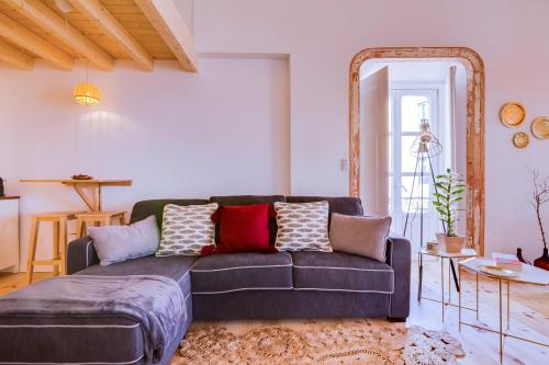 a living room with a couch and a mirror at A Casa D'Amelie in Faro
