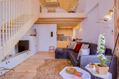 a living room with a couch and a staircase at A Casa D'Amelie in Faro