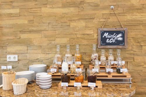 a display of food in jars on a table with plates at Hotel Bavaria Oldenburg in Oldenburg