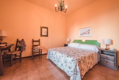 a bedroom with a bed and a table and chairs at Hotel Villa Sirina in Taormina