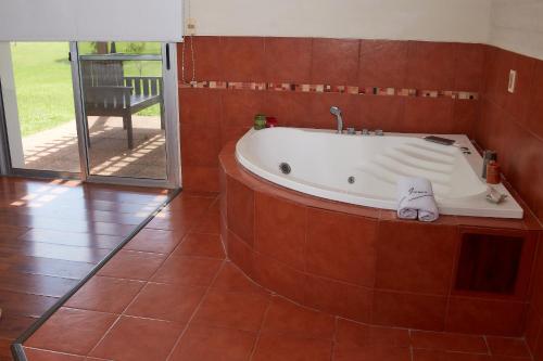 a bath tub in a room with a patio at Hotel Juana de Ibarbourou in Melo