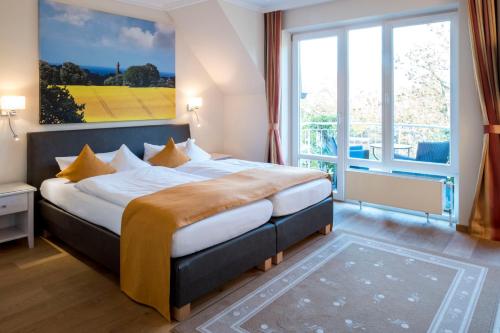 a bedroom with a large bed with a large window at Ringhotel Hohe Wacht in Hohwacht